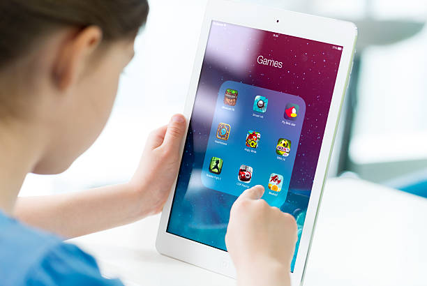 Kind hält ein iPad und hält einen Finger Richtung Bildschirm
